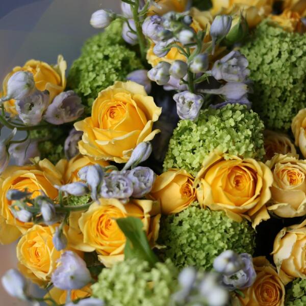 A bouquet of viburnum, spray peony roses and delphinium